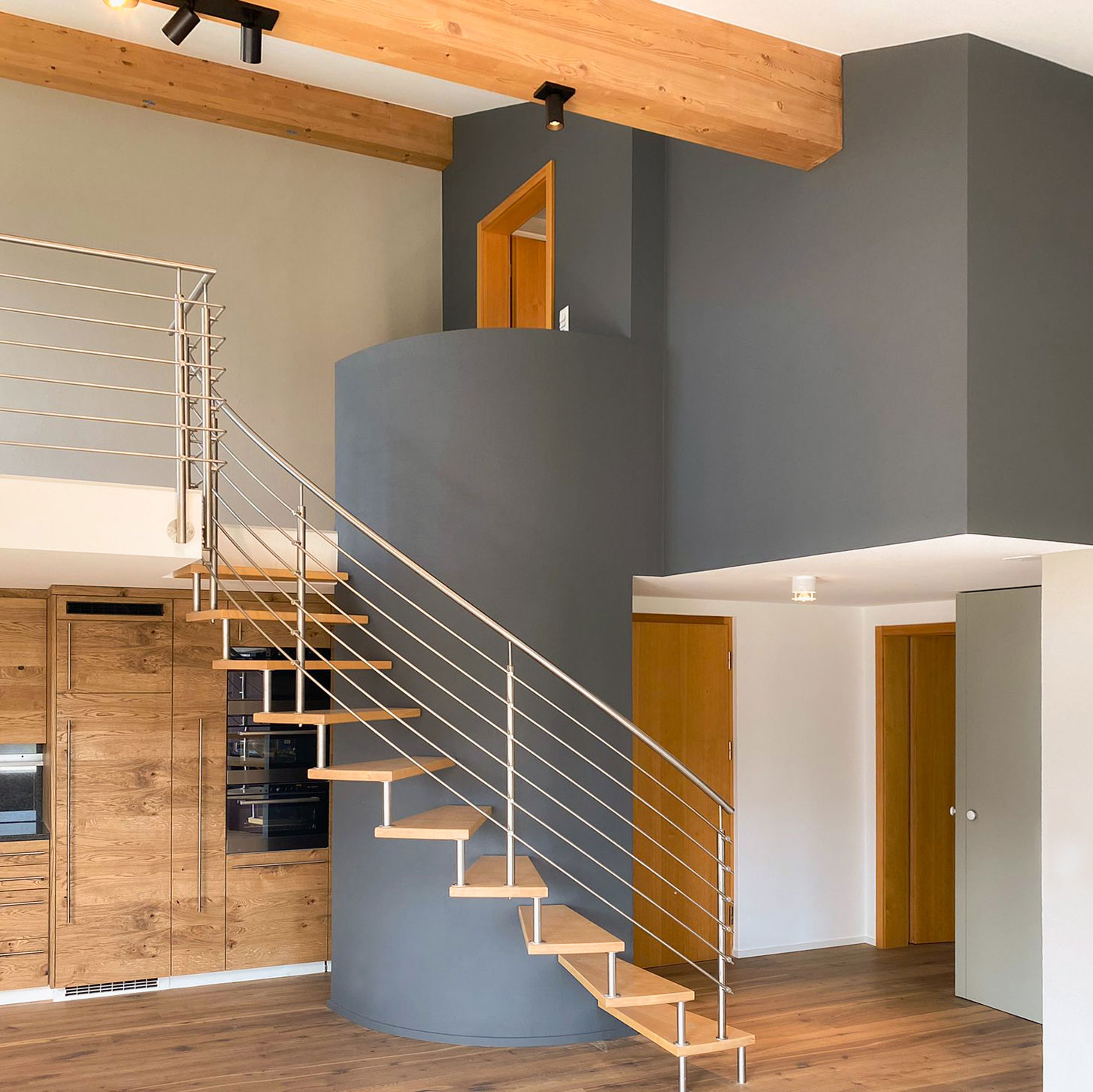 Ein kreatives Farbdesign für eine Ferienwohnung in den Bergen, das markante Kontraste zwischen Farben setzt und sowohl die Treppe als auch die angrenzende Galerie betont. Die Farrow & Ball-Farbe, die in der Treppe verwendet wird, fügt sich harmonisch in das Gesamtbild des Raumes ein und schafft eine elegante Verbindung zwischen den verschiedenen Ebenen. Die starken Farbakzente entlang der Treppe führen den Blick hinauf und schaffen ein spannendes visuelles Erlebnis. Die Galerie-Wand ergänzt das Farbkonzept und dient als beeindruckende Kulisse für Kunstwerke oder Dekorationen, die den Raum noch weiter aufwerten. Das Design kombiniert traditionelle und moderne Elemente, um eine einladende Atmosphäre zu schaffen, die sowohl rustikal als auch stilvoll wirkt.